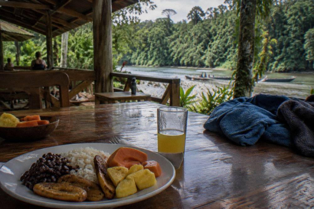 A spread of tropical fruit and a traditional Costa Rican lunch served on a table after a rafting trip